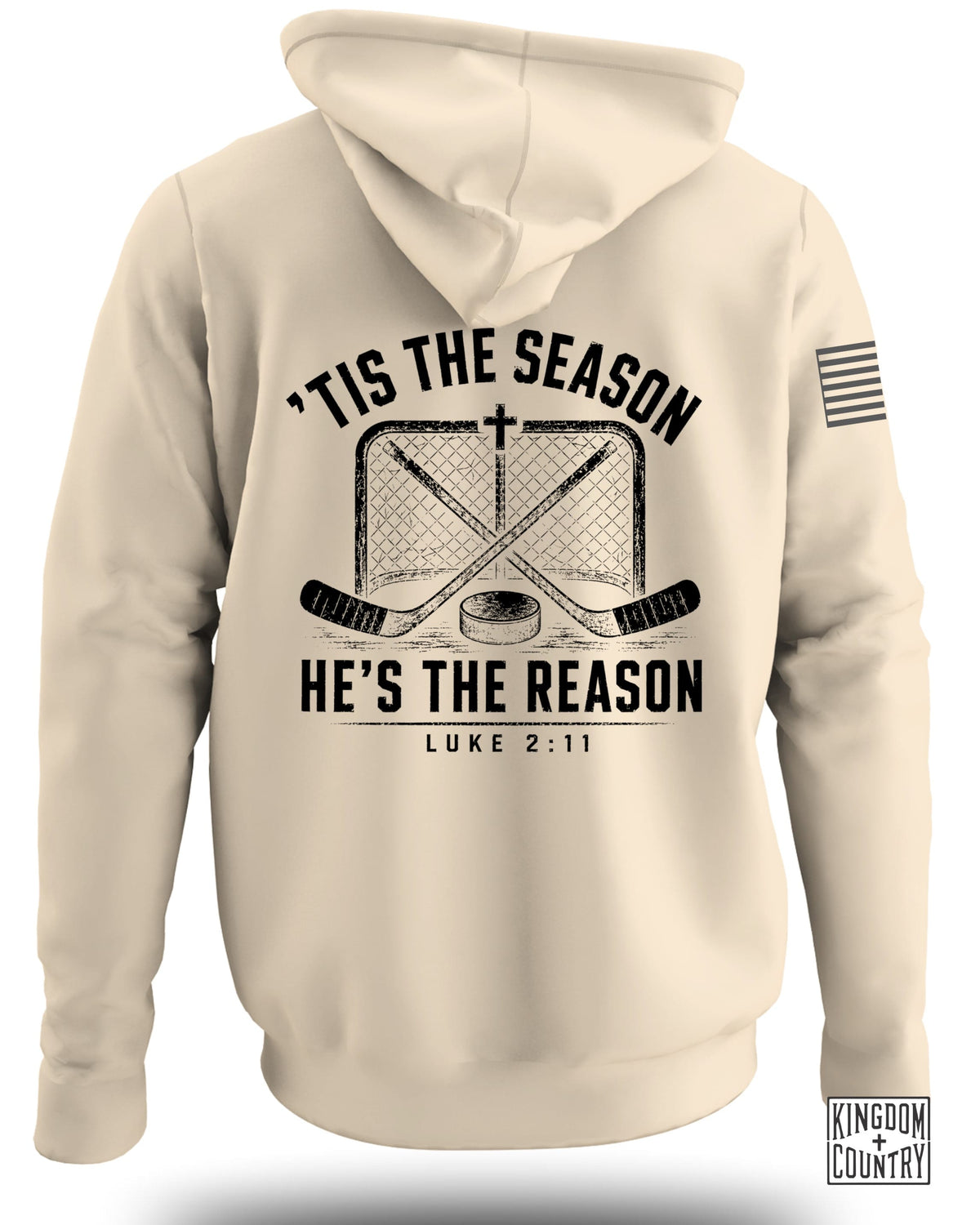 Back view of a beige hooded sweatshirt featuring hockey sticks, a net, and text reading Tis the Season He's the Reason Luke 2:11.