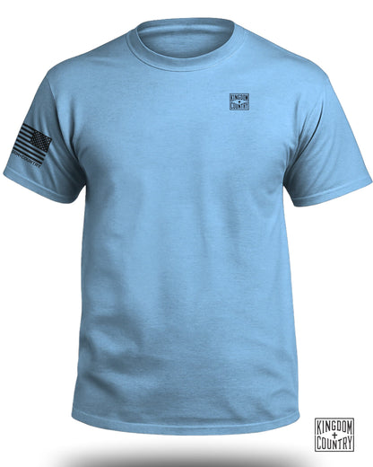 Light blue t-shirt with an American flag on the left sleeve and two logos.