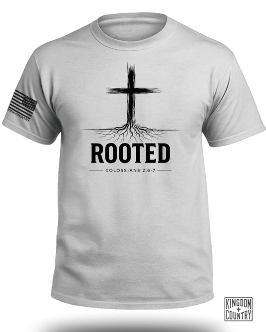 White t-shirt with black cross graphic, "ROOTED" text, and Bible verse.
