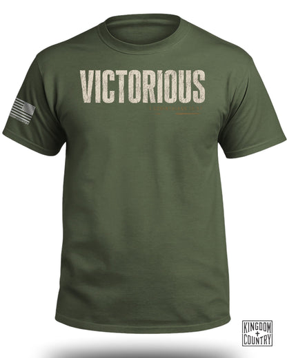 Olive green t-shirt with "VICTORIOUS" and scripture text, and an American flag on the sleeve.