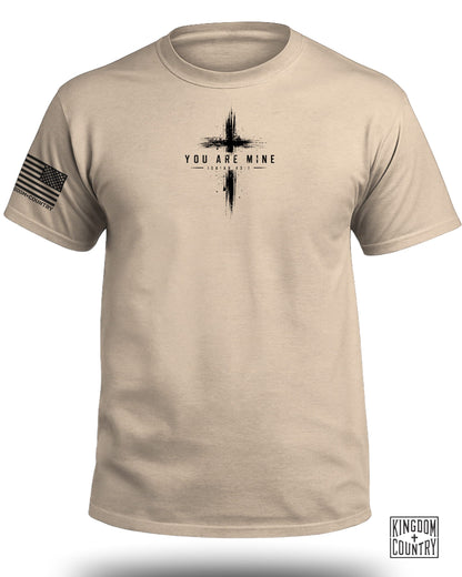 Tan t-shirt with a distressed cross and "You Are Mine Isaiah 43:1" graphic.