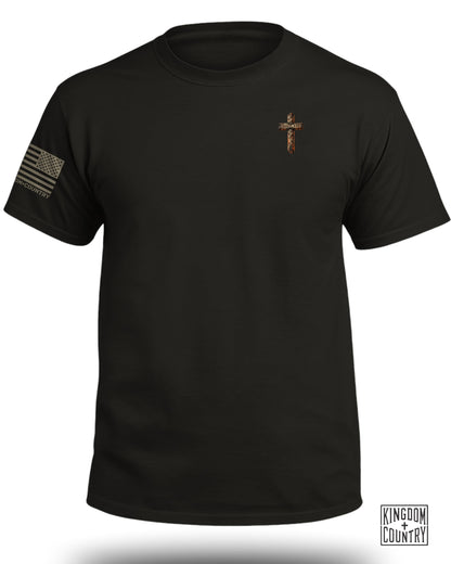 Black t-shirt with American flag sleeve and wooden cross with "Daniel 3:25" text.