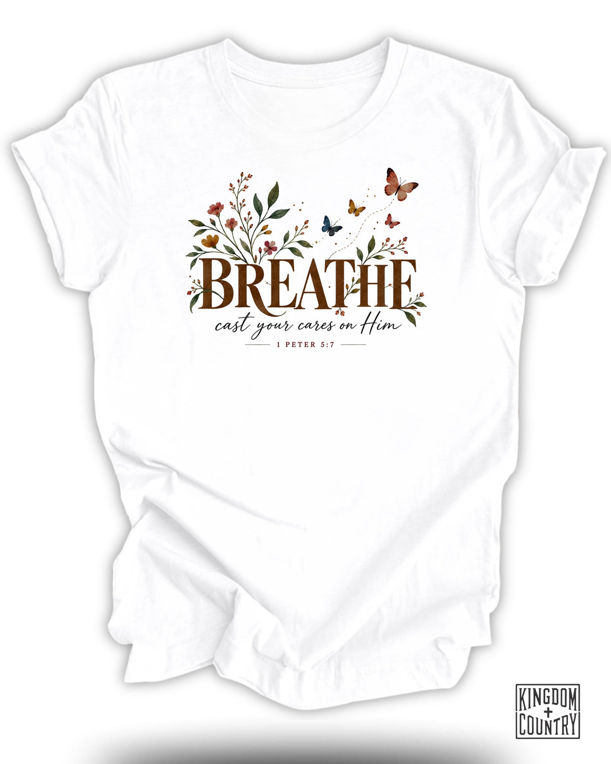 White t-shirt with "BREATHE cast your cares on Him 1 PETER 5:7" text and floral design.