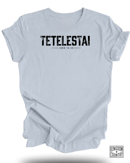 Light blue t-shirt with black text "TETELASTAI JOHN 19:30" and a logo.