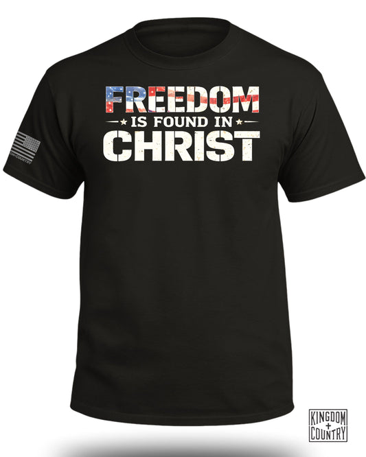 Black t-shirt with "FREEDOM IS FOUND IN CHRIST" in distressed American flag text.