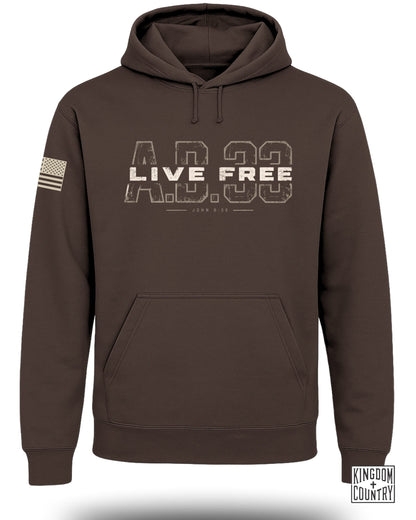 Dark brown hooded sweatshirt featuring "LIVE FREE A.D. 33" graphic across the chest and American flag on the sleeve.