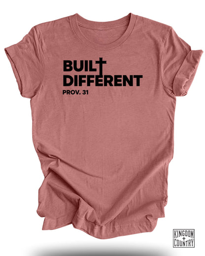 Rose-colored t-shirt with black text "BUILT DIFFERENT PROV. 31" and small logo.