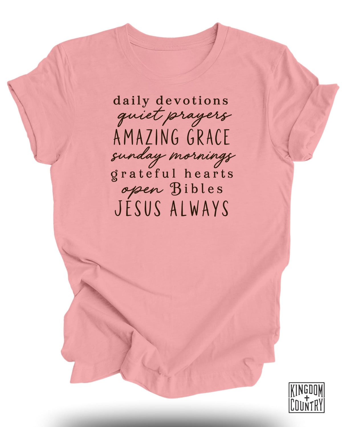 Pink t-shirt with black text: "daily devotions quiet prayers AMAZING GRACE sunday mornings grateful hearts open Bibles JESUS ALWAYS".