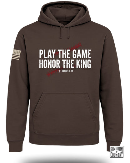 Brown hooded sweatshirt with text Play the Game Honor the King over a baseball stitch graphic.