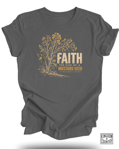 Gray t-shirt with mustard plant graphic and text "FAITH THE SIZE OF A MUSTARD SEED MATTHEW 17:20".