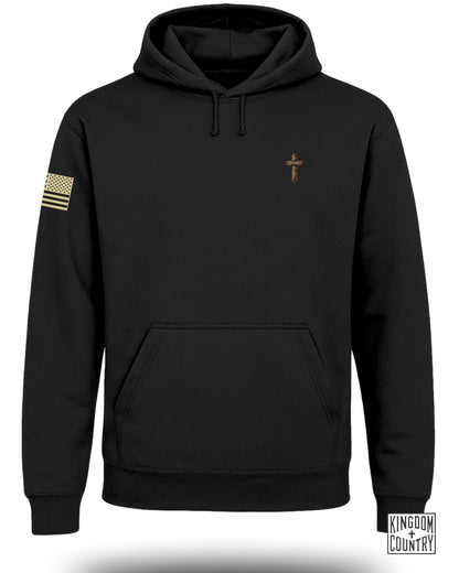 Black hoodie with American flag patch and cross graphic reading Daniel 3:25.