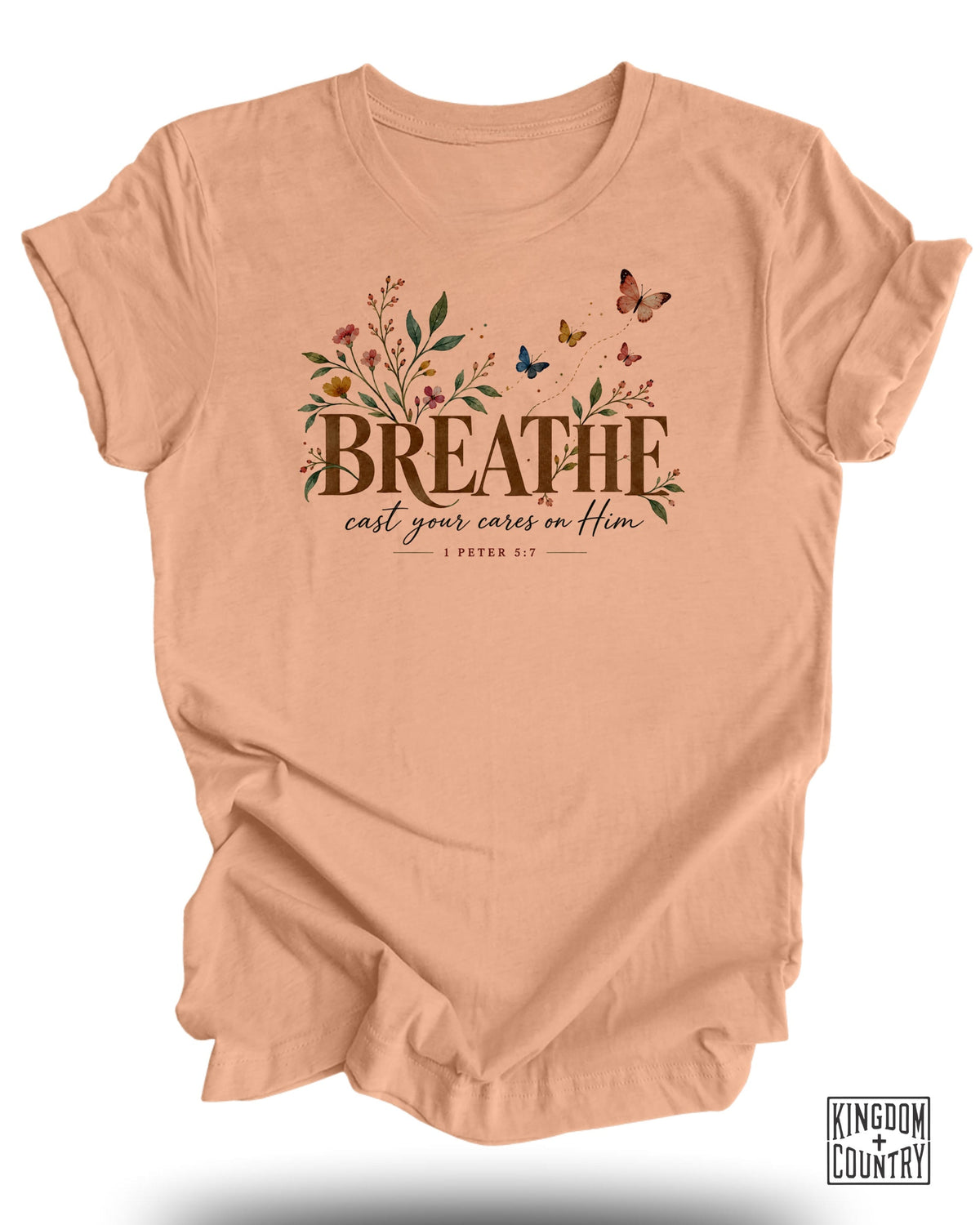 Peach t-shirt with floral design and text "BREATHE cast your cares on Him 1 Peter 5:7".