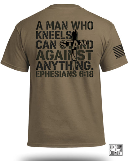 Brown t-shirt with "A MAN WHO KNEELS CAN STAND AGAINST ANYTHING. EPHESIANS 6:18" and US flag.