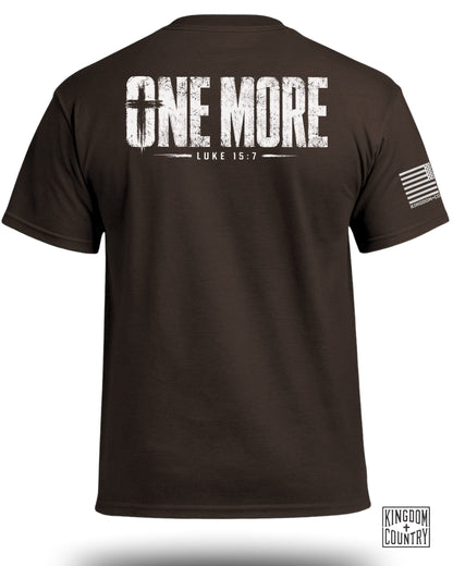 Brown t-shirt with white text "ONE MORE LUKE 15:7" and US flag graphic.