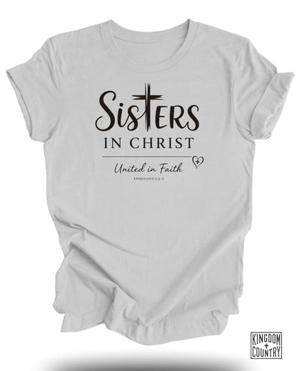 White t-shirt with "Sisters in Christ United in Faith" and "Ephesians 4:2-3" text.