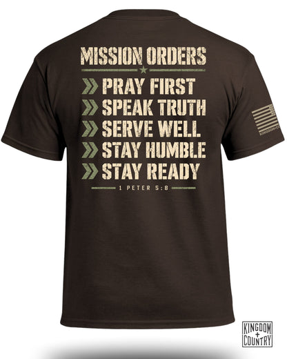 Brown t-shirt with "MISSION ORDERS" and "PRAY FIRST", "SPEAK TRUTH", "SERVE WELL", "STAY HUMBLE", "STAY READY" listed.