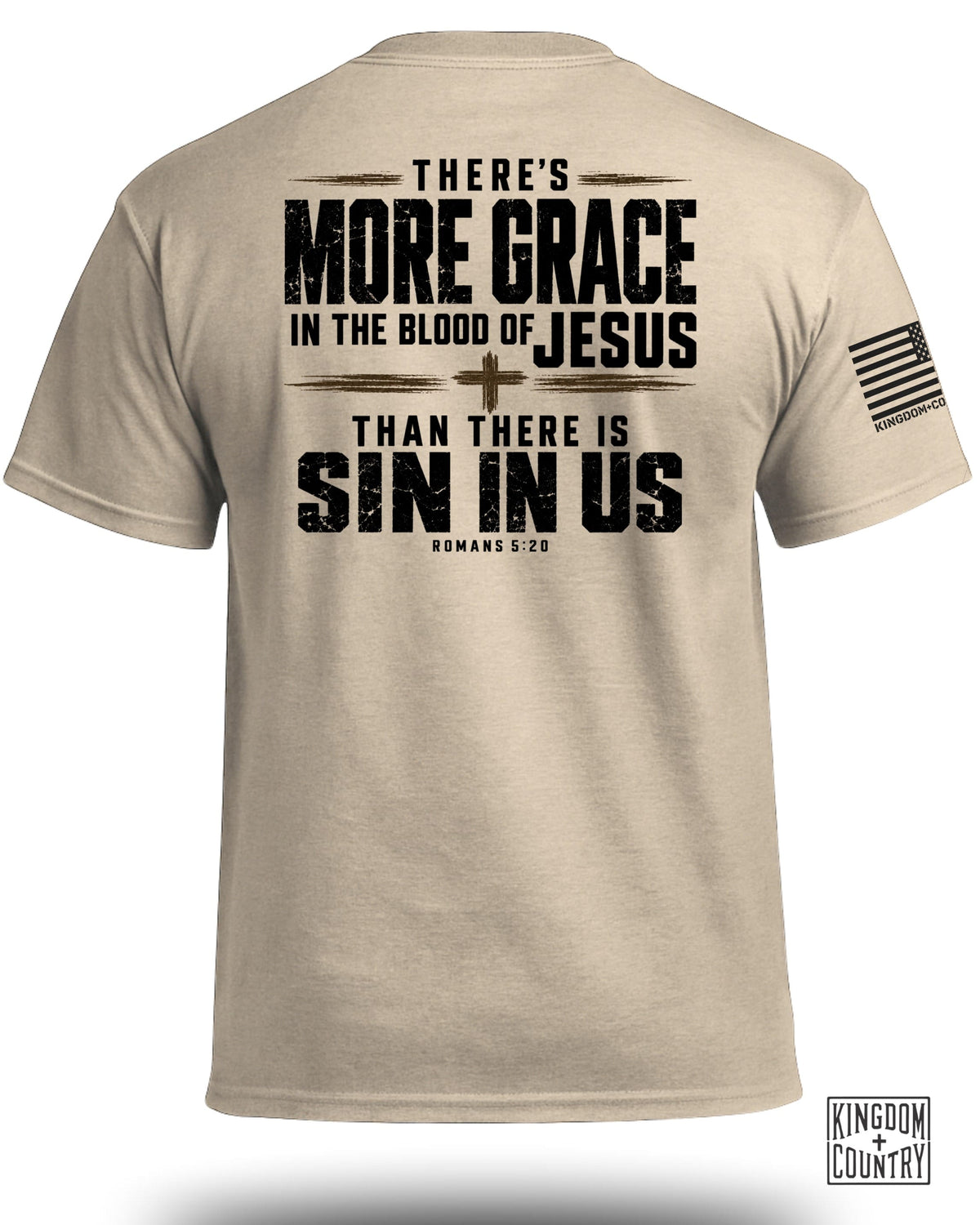 A tan t-shirt with black text on the back that reads "There's more grace in the blood of Jesus than there is sin in us Romans 5:20."