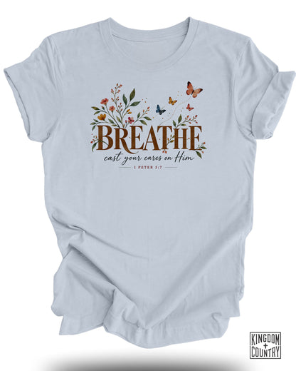 Light blue t-shirt with "BREATHE cast your cares on Him" and Bible verse 1 Peter 5:7.