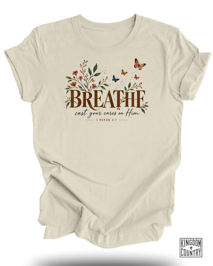 Cream t-shirt with "BREATHE cast your cares on Him" text and floral butterfly design.