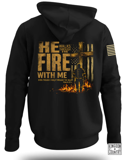 Black hoodie with gold text "HE WALKS THROUGH THE FIRE WITH ME" and Psalm 23:4.