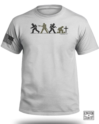 Light gray crewneck t-shirt featuring firefighter graphics, Bible verse text, and an American flag sleeve patch.