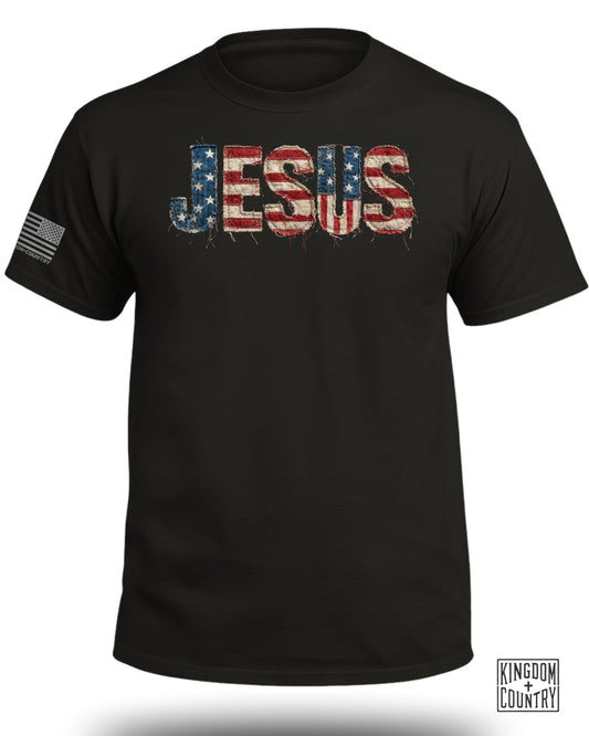 Black t-shirt with "JESUS" text in distressed American flag design.