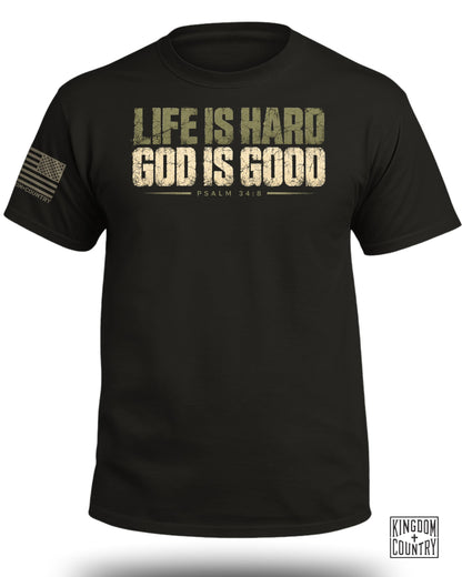 Black t-shirt with distressed text "LIFE IS HARD GOD IS GOOD PSALM 34:8" and American flag patch.