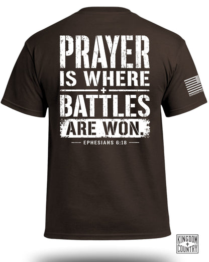 Brown t-shirt with white text reading "PRAYER IS WHERE BATTLES ARE WON. EPHESIANS 6:18."